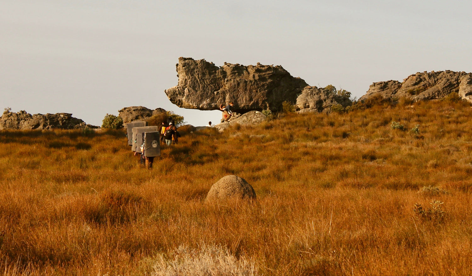 Desert landscape with large rock formations and a vehicle in the foreground
